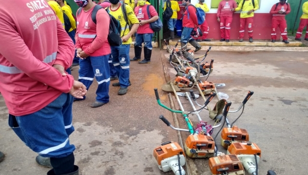 Com roçadeiras, garis e roçadores fecham entrada da Zeladoria da Cidade por causa de atraso de salários 